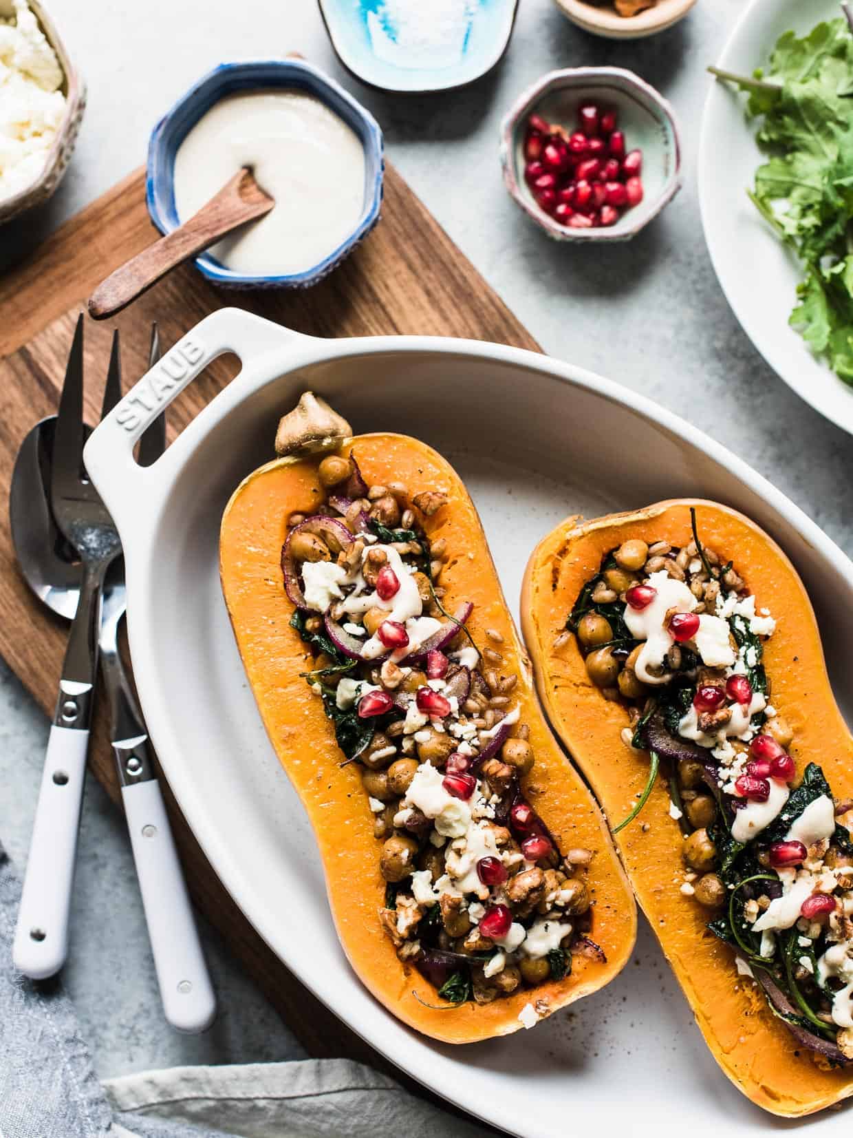 Stuffed Butternut Squash halved and prepared with a filling of chickpeas, baby kale, red onion, feta, and more.