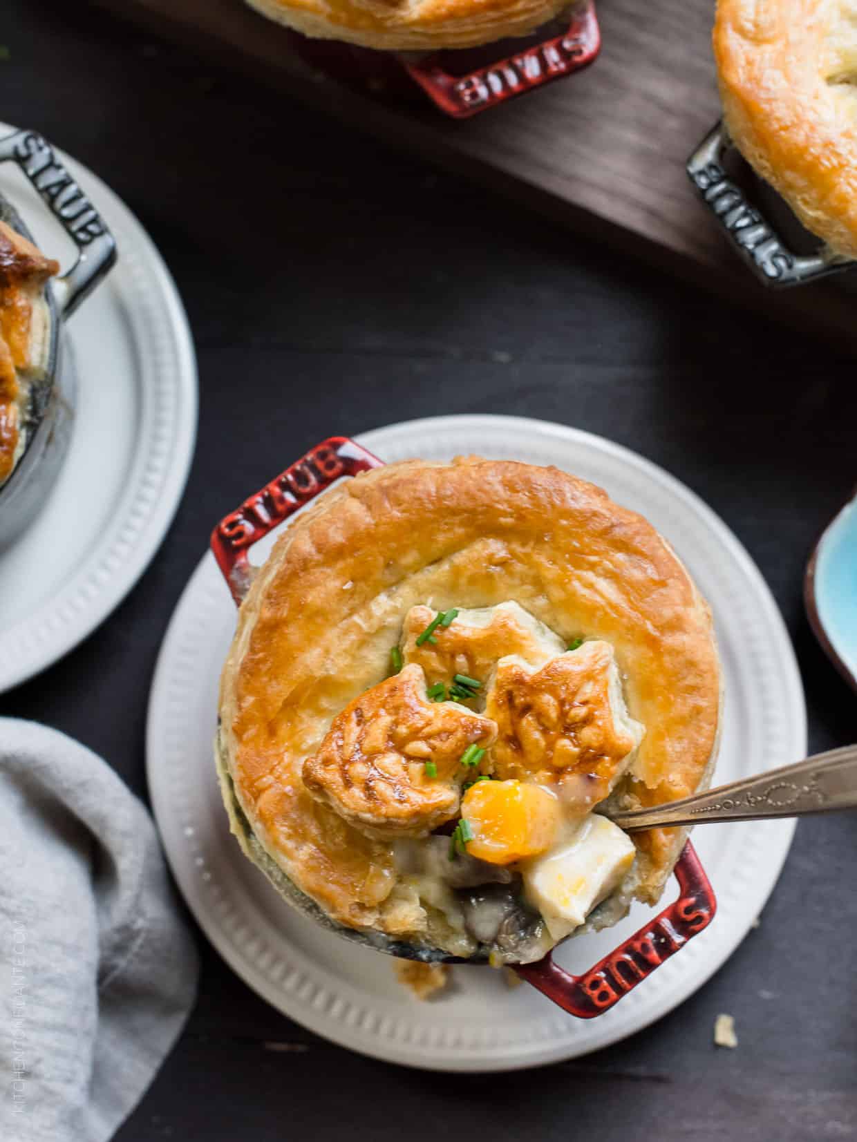 Single serving Turkey Pumpkin Pot Pie topped with golden-brown puff pastry in a red Dutch oven.