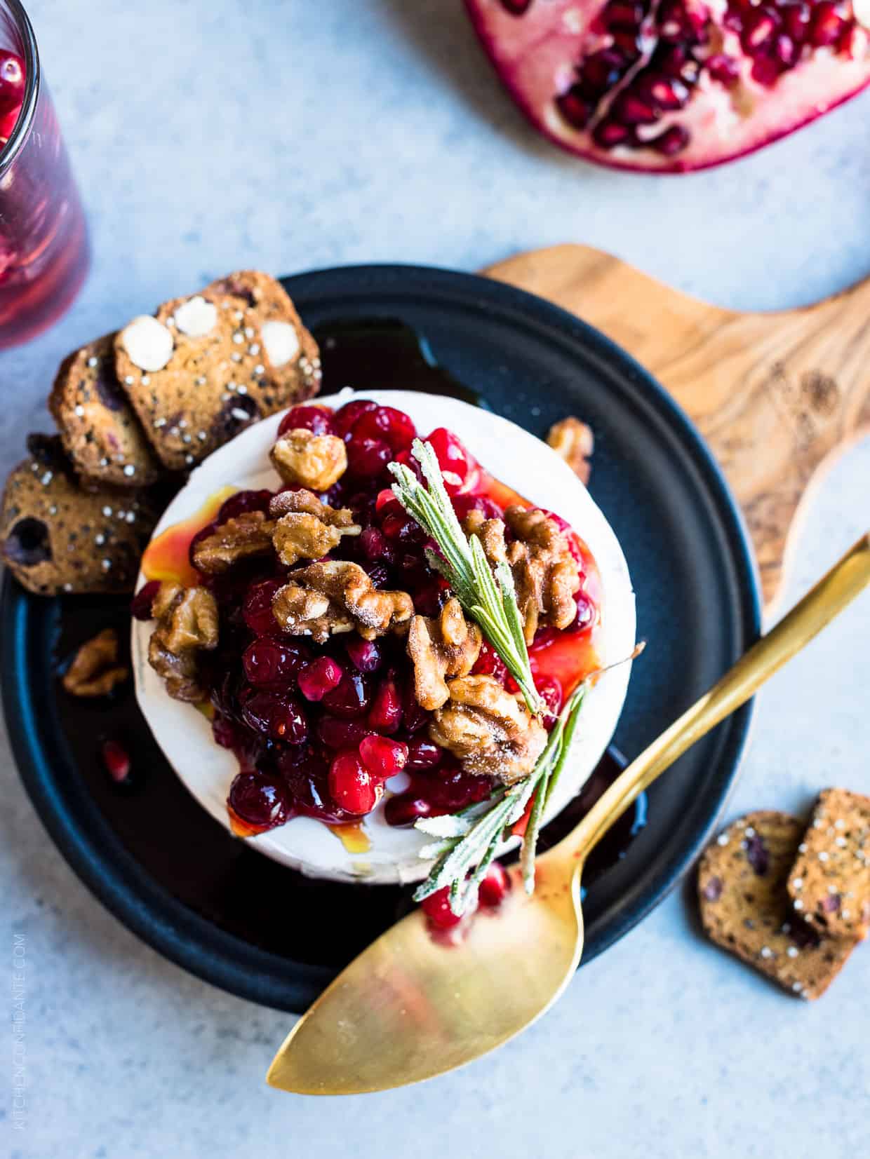 Cranberry Pomegranate Baked Brie served on a black plate.