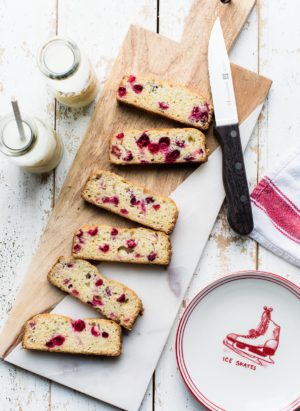 Slices of Cranberry Tea Cake on a marble and wood cutting board.