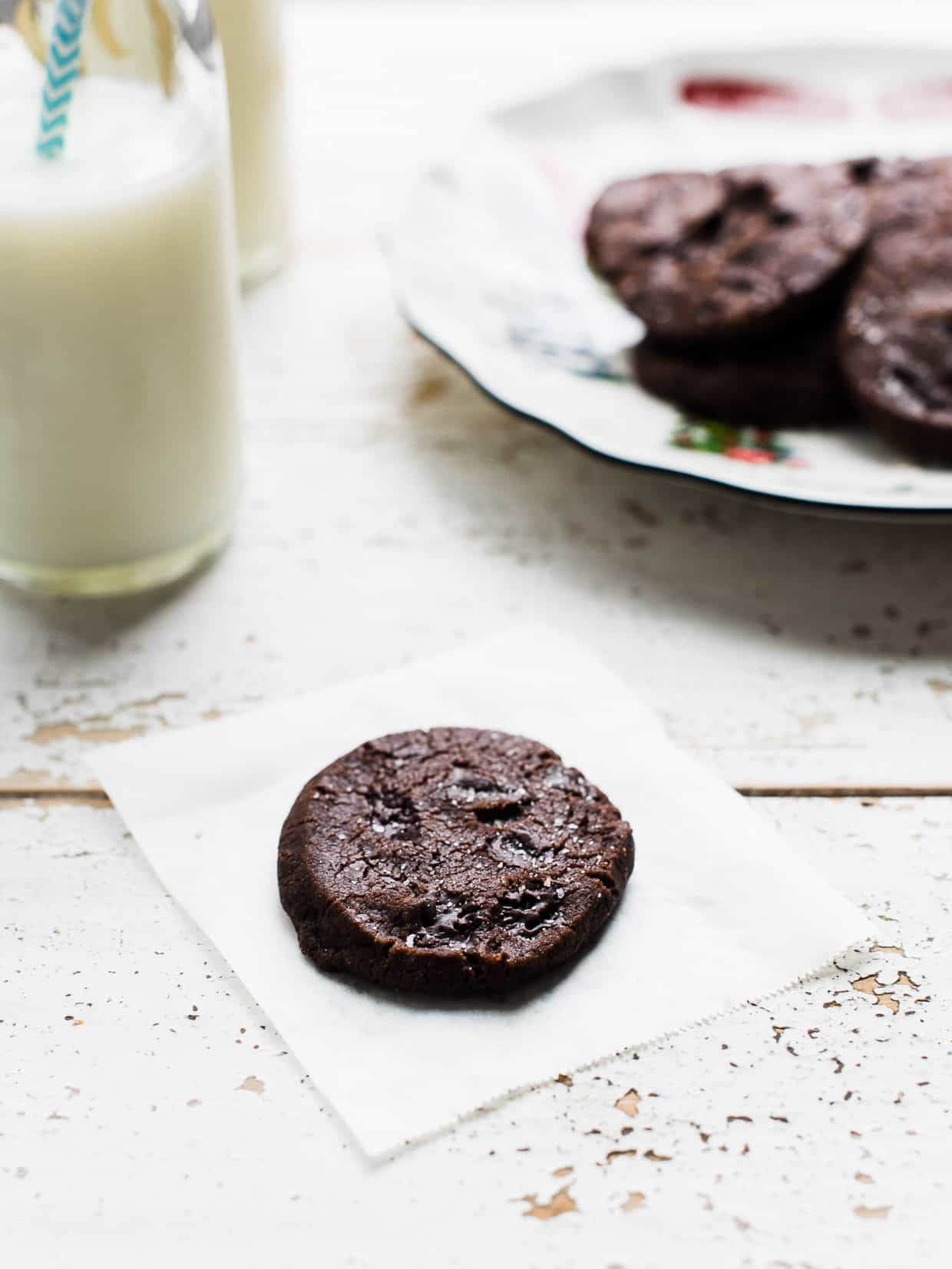 Chocolate cookie served with milk on a rustic surface.