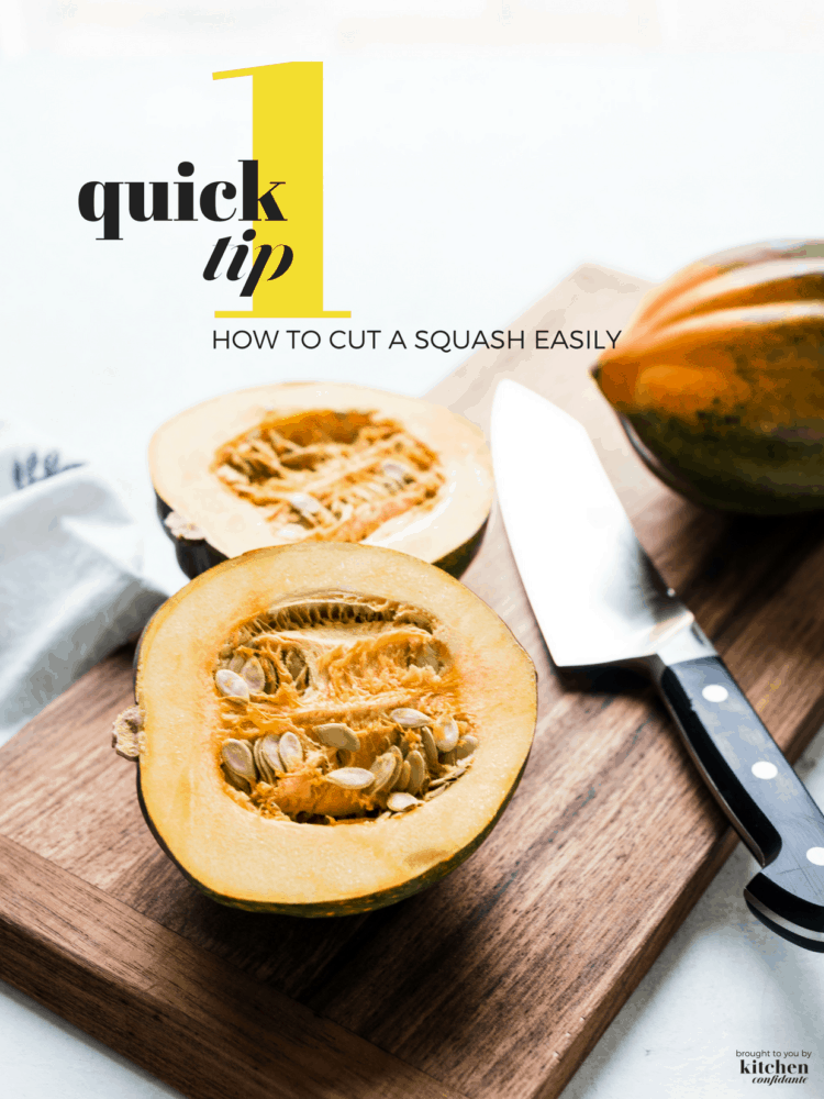 Acorn squash on a wooden cutting board cut in half with a chef's knife.