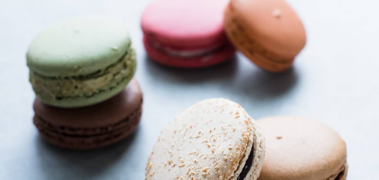 Selection of macaron cookies arranged on a counter top.