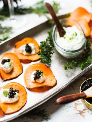 Sweet Potato Chips with Whipped Goat Cheese and Caviar on a serving tray with additional whipped goat cheese alongside.
