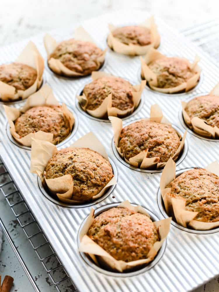 A tray of freshly baked applesauce muffins sitting on a cooling rack.