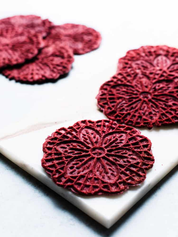 Red Velvet Pizzelle on a marble surface.