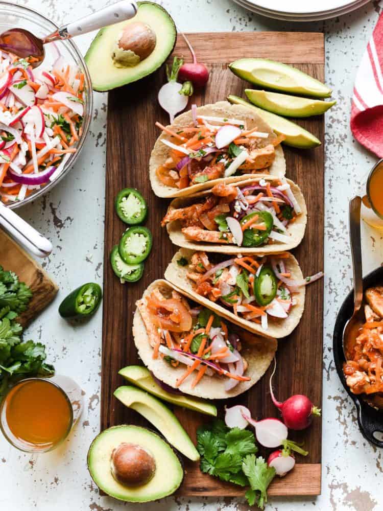 Chipotle Chicken Tacos on a wooden board served with Jicama Slaw.