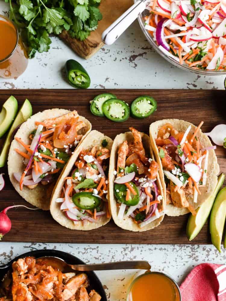 Chicken tacos on a wooden board.