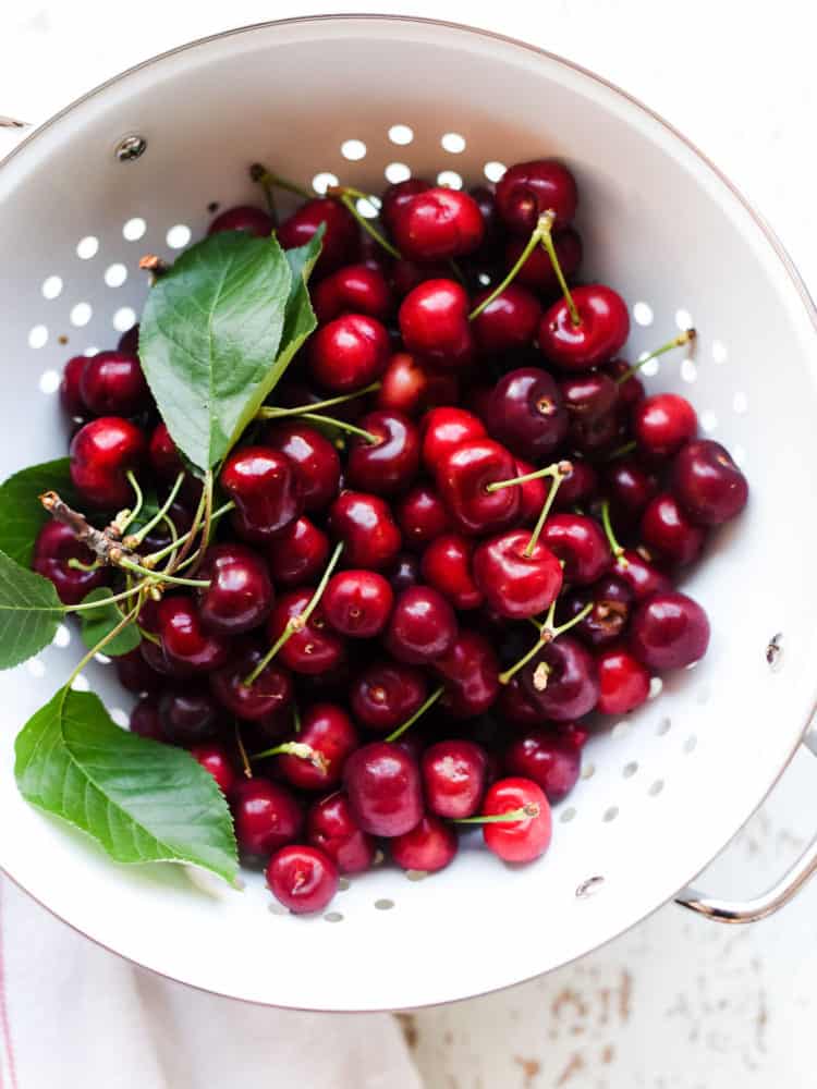 Fresh cherries in a white colander to make Homemade Cherry Pop Tarts