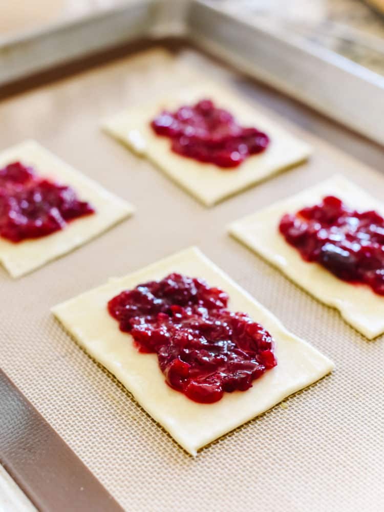 Fresh cherry jam filling on rectangles of pop tart dough to make Homemade Cherry Pop Tarts