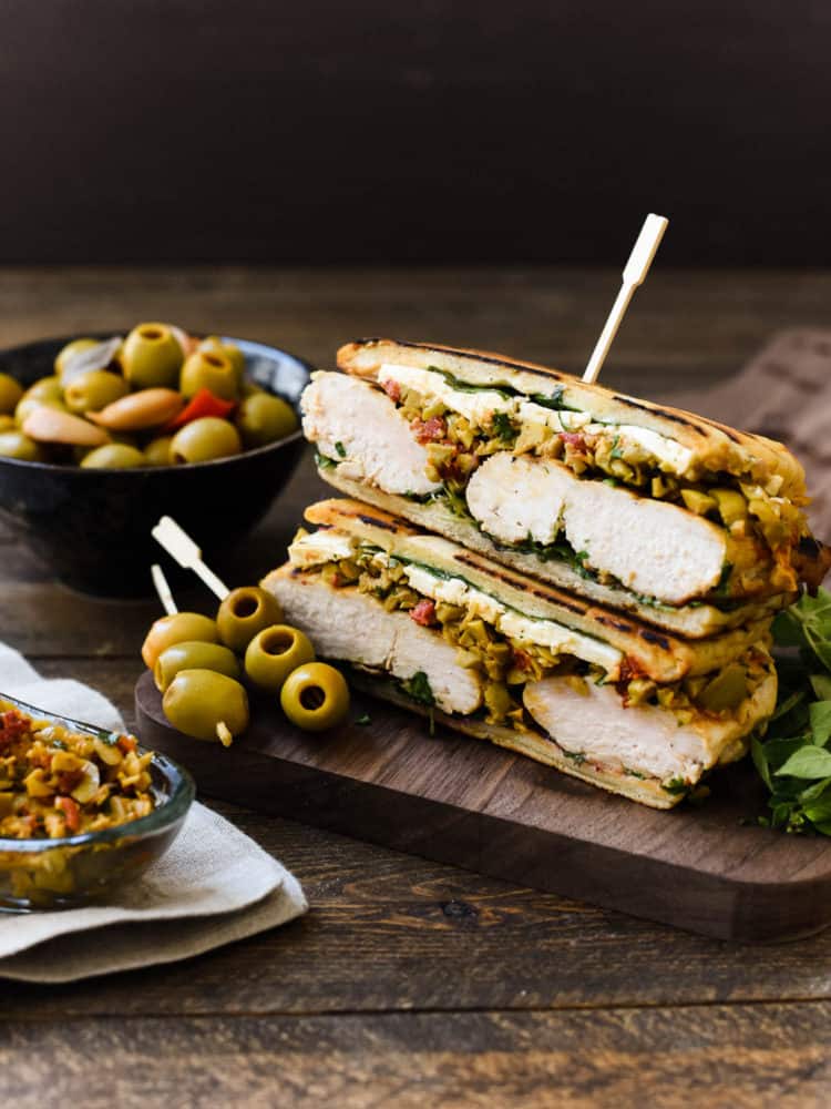 Olive-brined Chicken Sandwich with Olive Tapenade gets its incredible flavor from chicken brined in a Spanish blend olive brine, savory feta cheese, and a hearty spread of olive tapenade. This post is sponsored by Lindsay olives.
