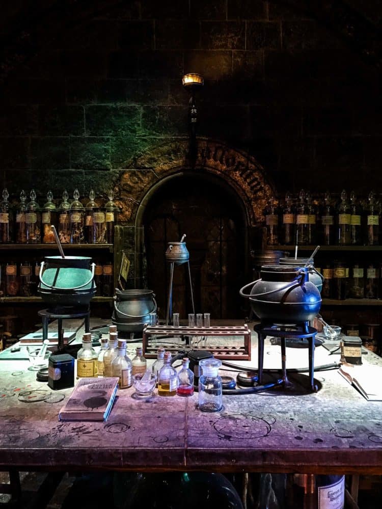 Test tubes, caldrons, and bottles of chemicals in a dark, stone lab in the Potions Room at Warner Bros. Studio Tour. 