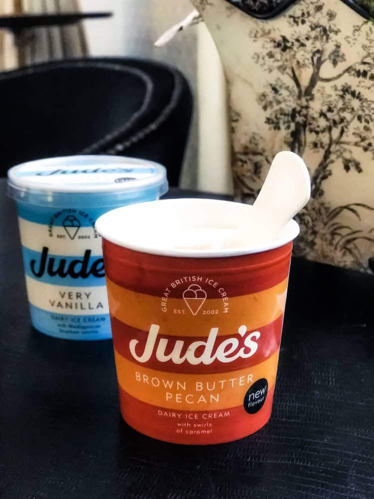 Pints of Jude's Ice cream on a dark surface.