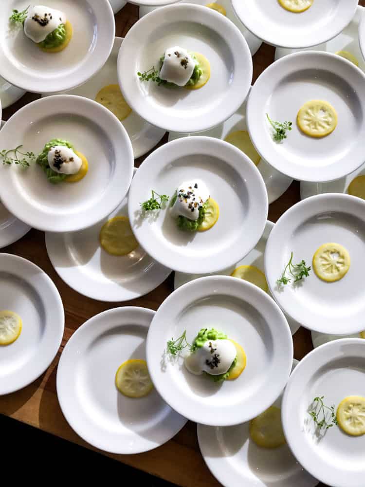 Stacks of white plates with risotto and lemon slices from the Pebble Beach Food & Wine 2017.