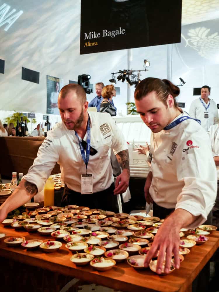 Two men arranging small bowls of appetizers at the Pebble Beach Food & Wine.