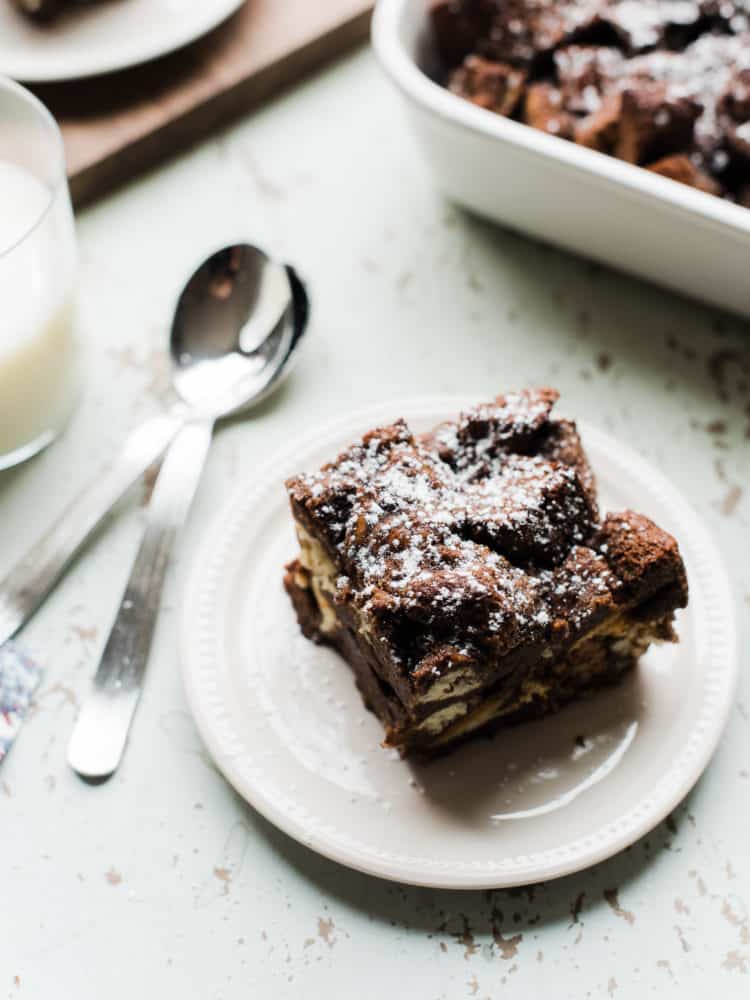 Chocolate bread pudding serving on a white plate.