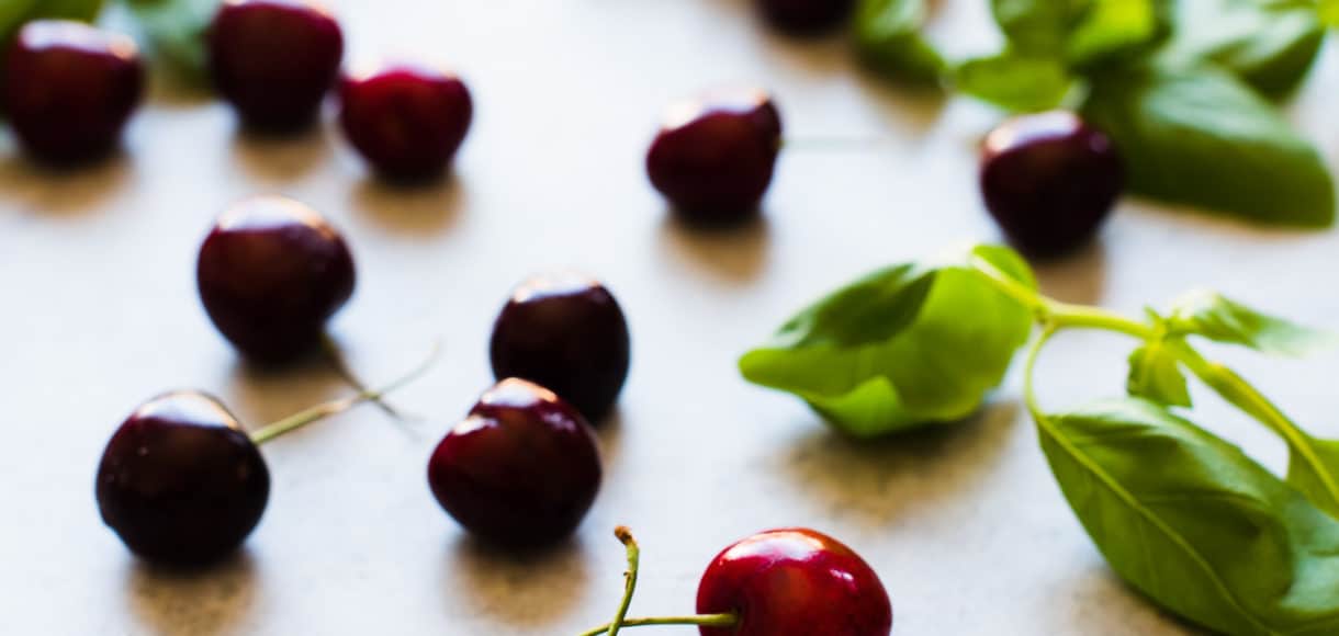 Fresh cherries spread out on a countertop.
