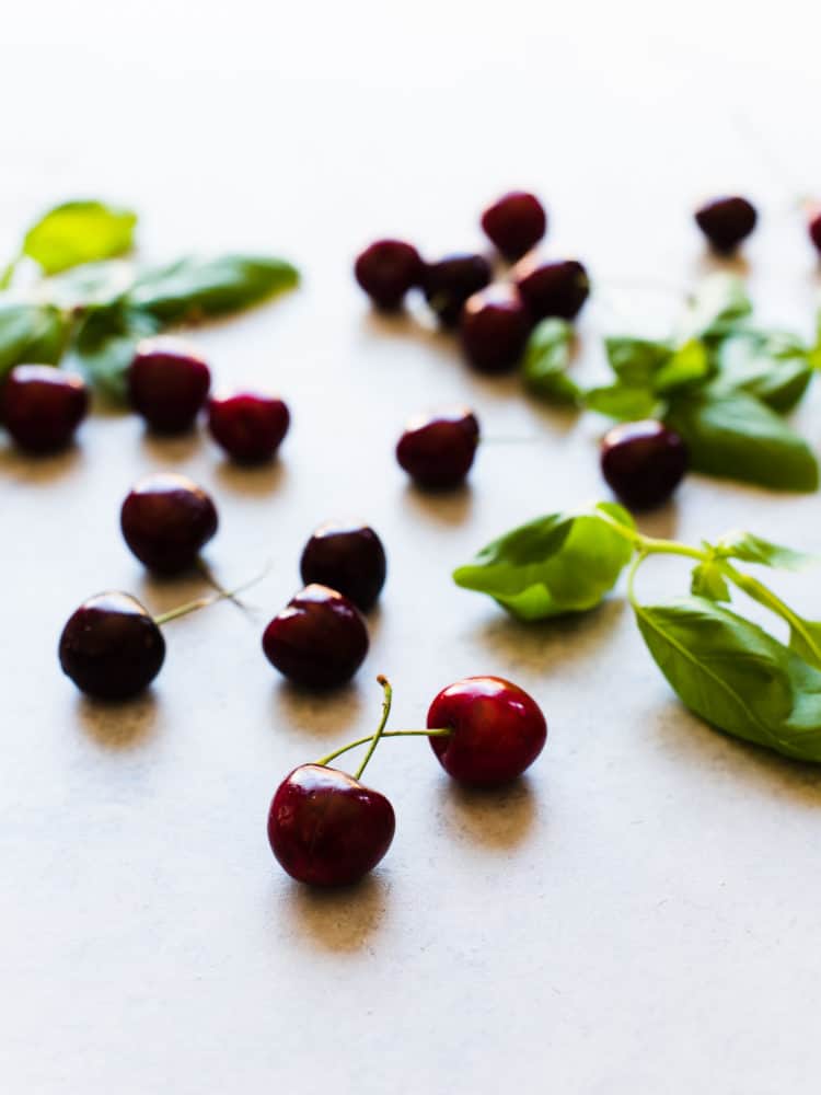 Fresh cherries spread out on a countertop.