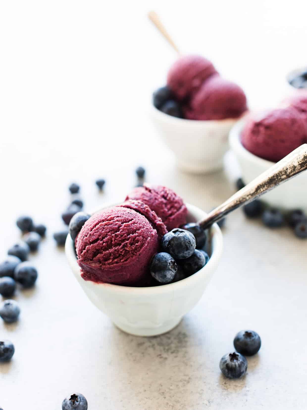 Blueberry Açaí Frozen Yogurt served in small white bowls with blueberries for garnish.