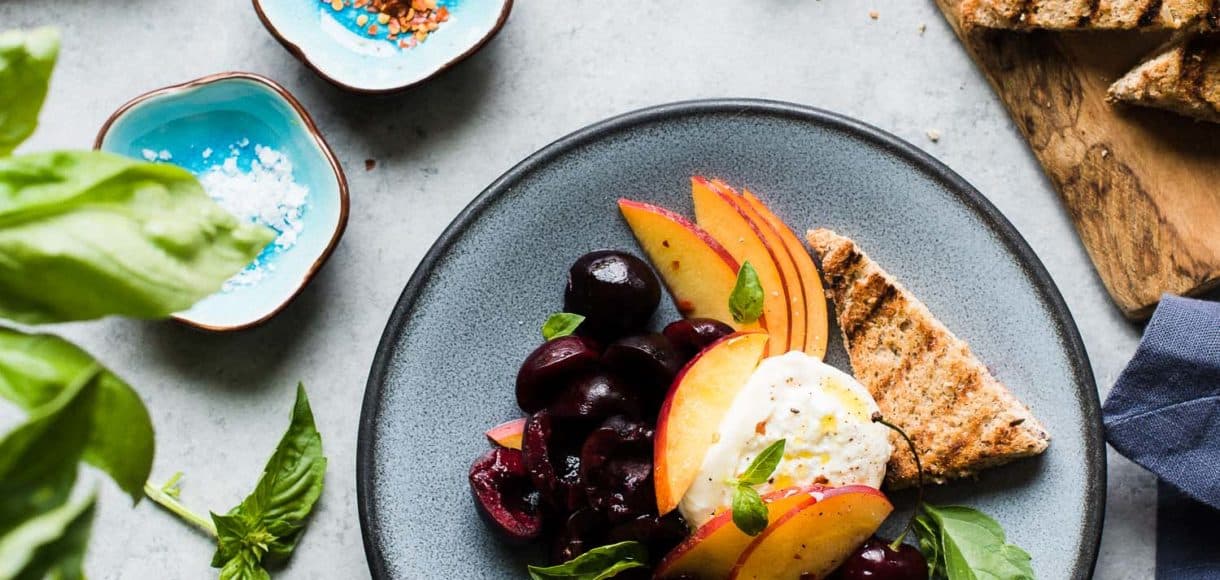 Summer stone fruit, fresh basil, and creamy burrata dressed in a zingy balsamic vinegar and olive oil is the perfect summer appetizer!