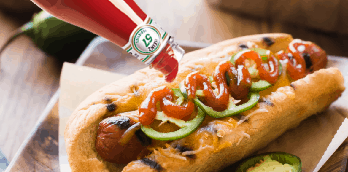 Sriracha Hot Dogs in a bun with cheese and jalapeños.