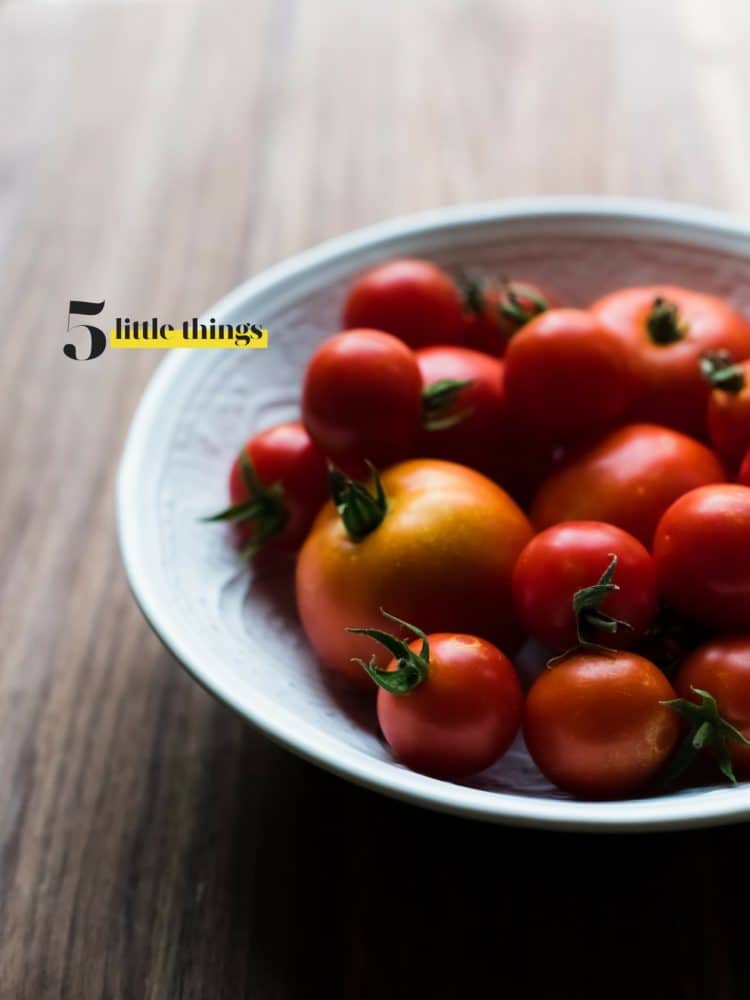 A white bowl of red tomatoes.