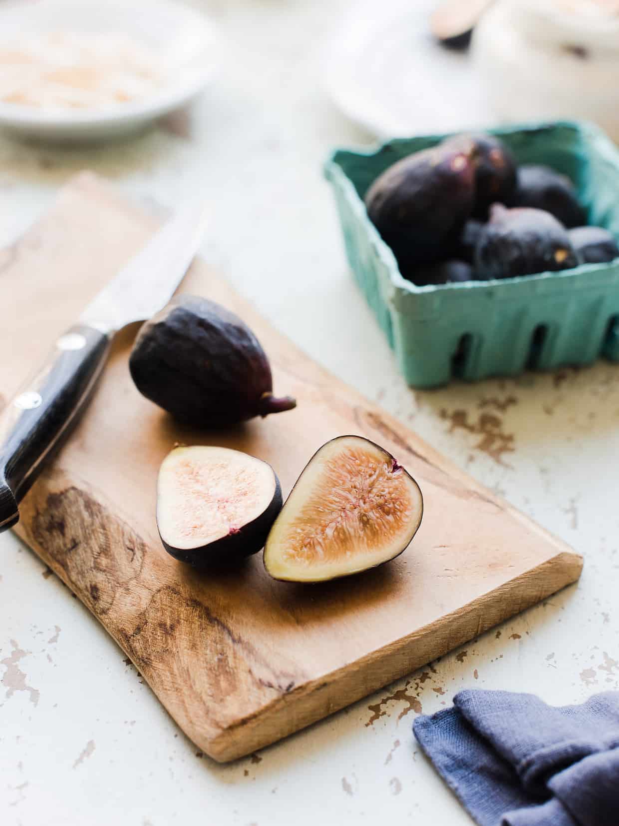 Sliced fresh figs on a wooden cutting board.