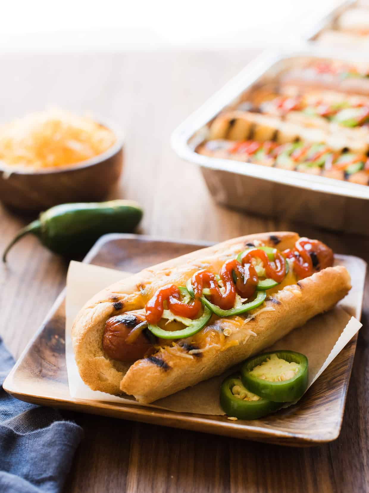 Sriracha Hot Dogs in a bun with cheese and jalapeños.