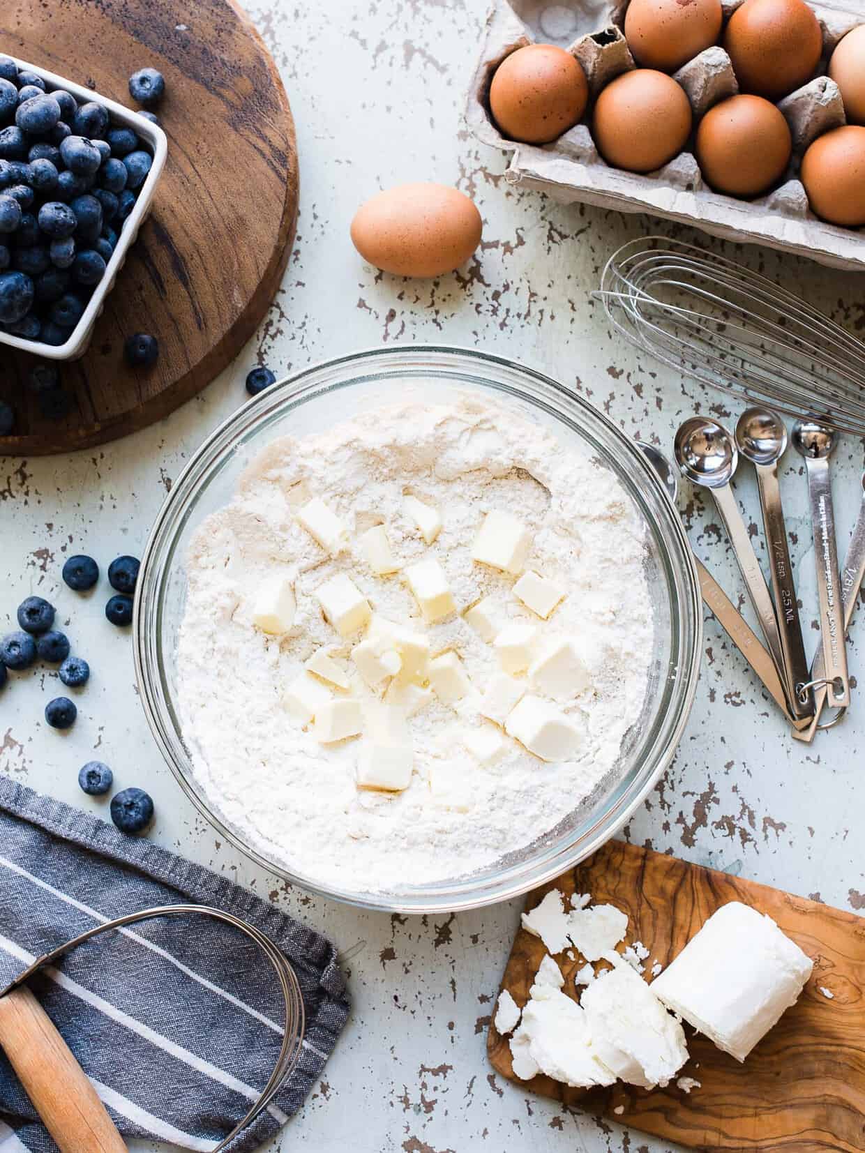 Flour, butter, eggs, blueberries and goat cheese ready to make blueberry goat cheese scones.