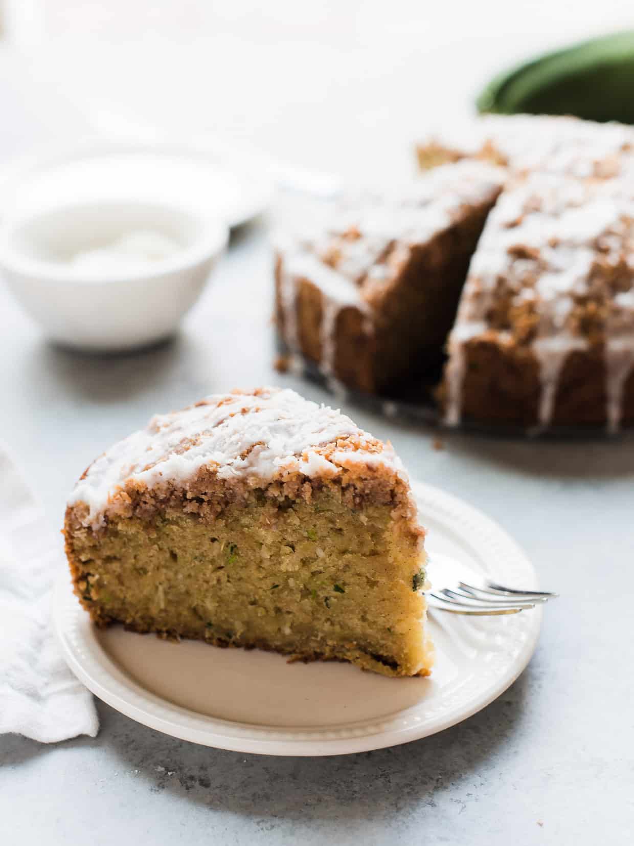 A slice of coconut zucchini coffee cake on a white plate.