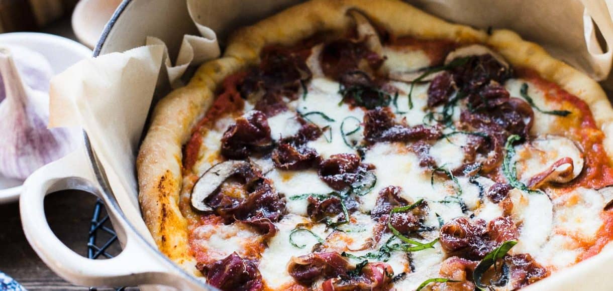 Dutch Oven Pizza baked in a Dutch oven lined with parchment paper.