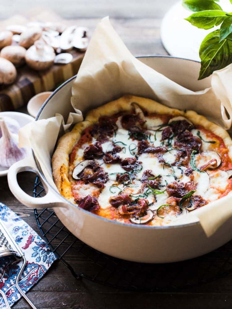 Dutch Oven Pizza baked in a Dutch oven lined with parchment paper.