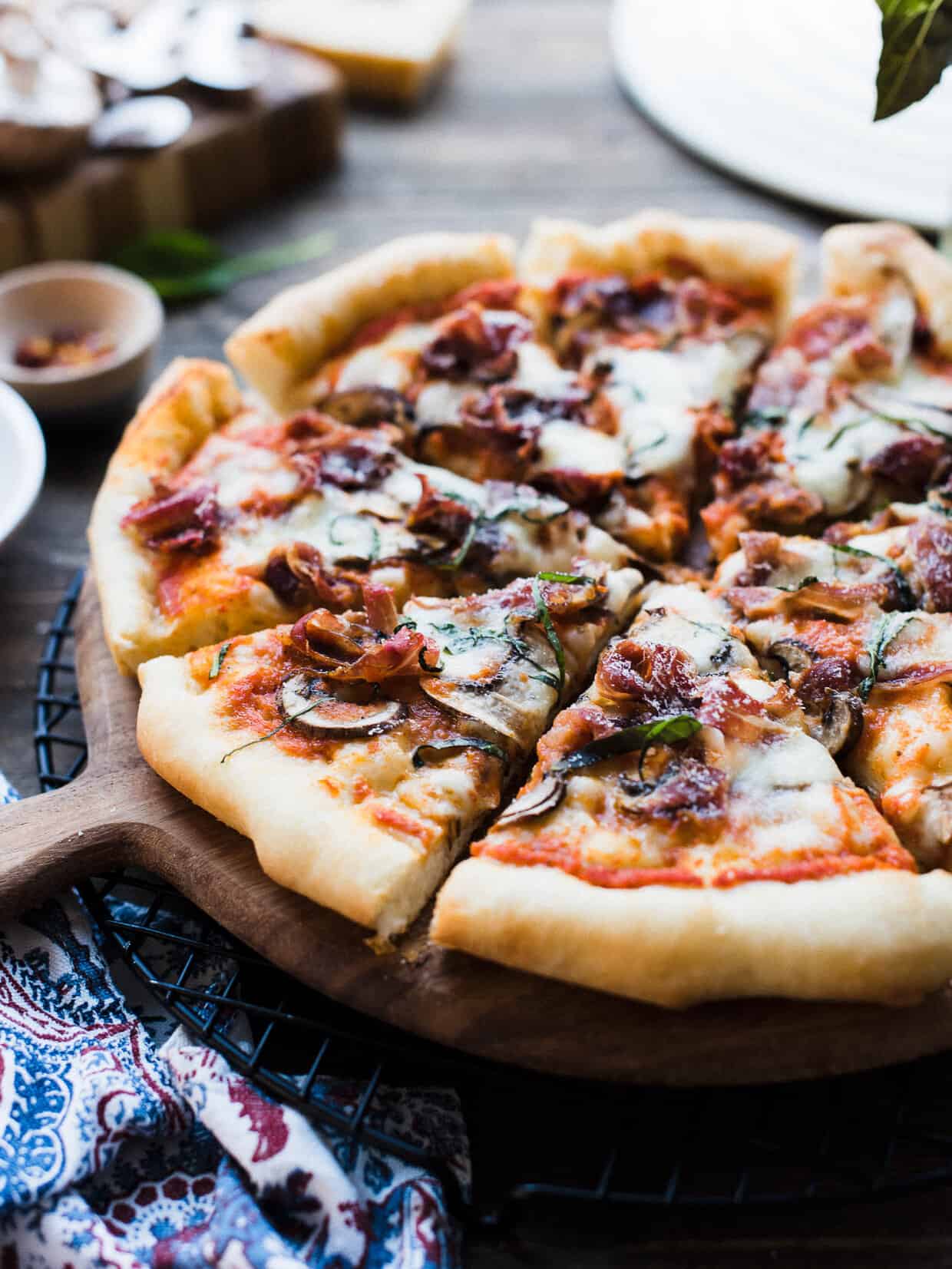 Homemade pizza sliced and served on a wooden board.