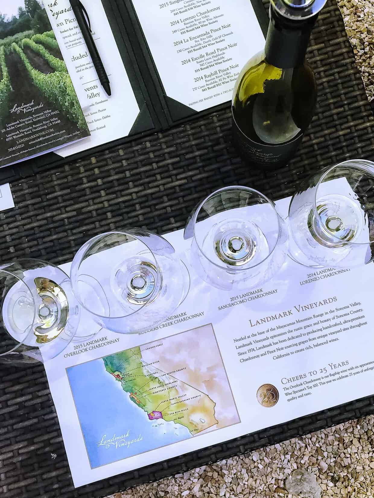 Top down view of 4 wine glasses on a wicker table at a wine tasting.