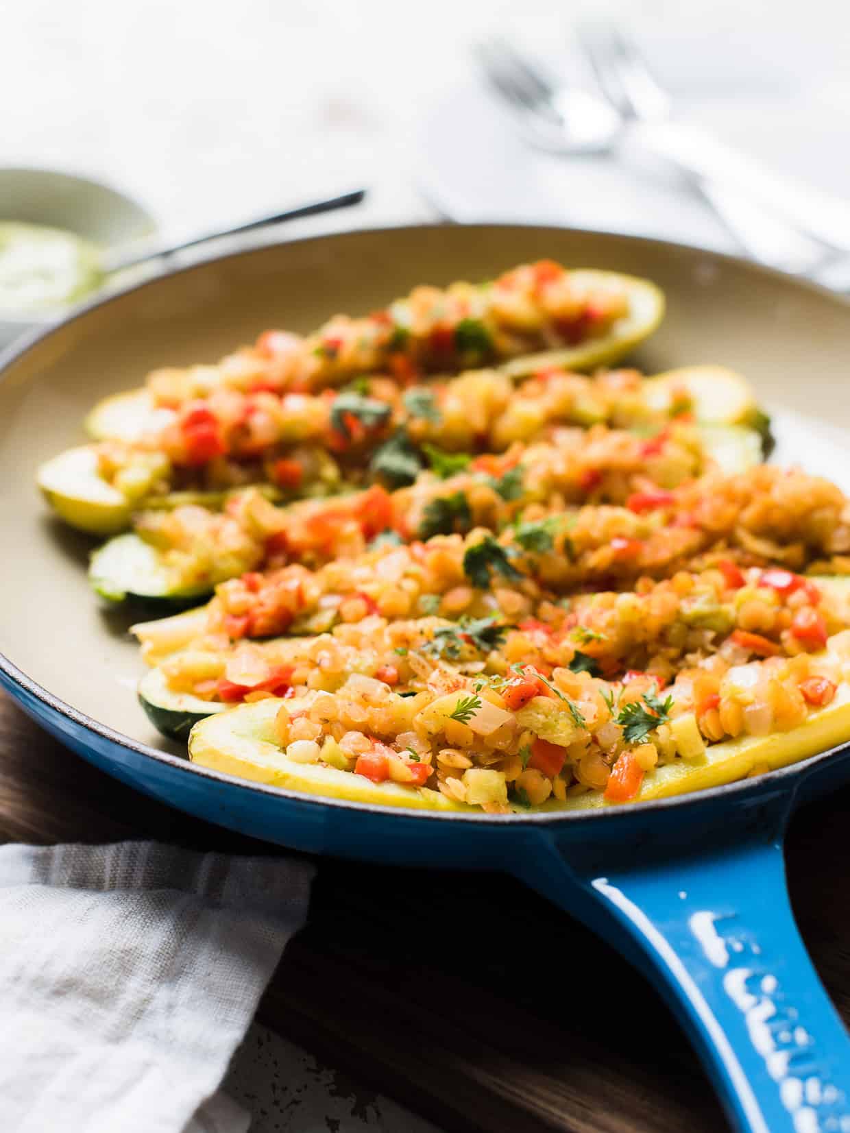 Stuffed yellow squash and zucchini with a tasty lentil filling in a shallow pan.