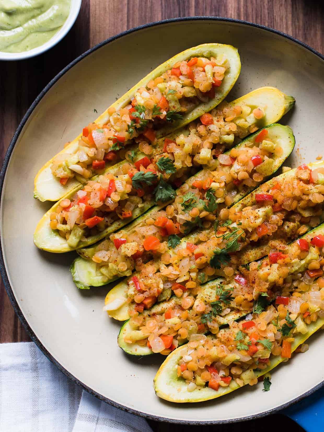 Stuffed yellow squash and zucchini with a tasty lentil filling in a shallow pan.