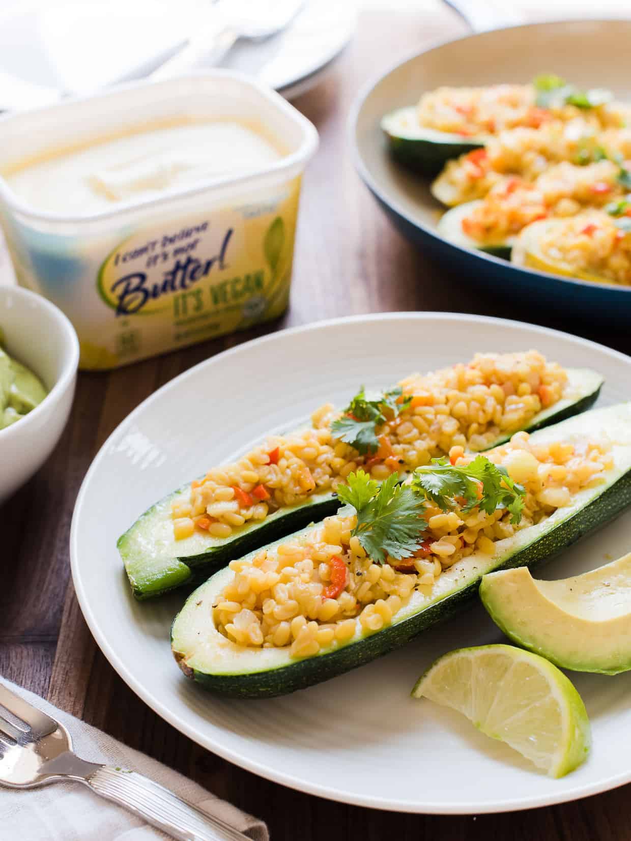 Stuffed yellow squash and zucchini with a tasty lentil filling served on a white plate.