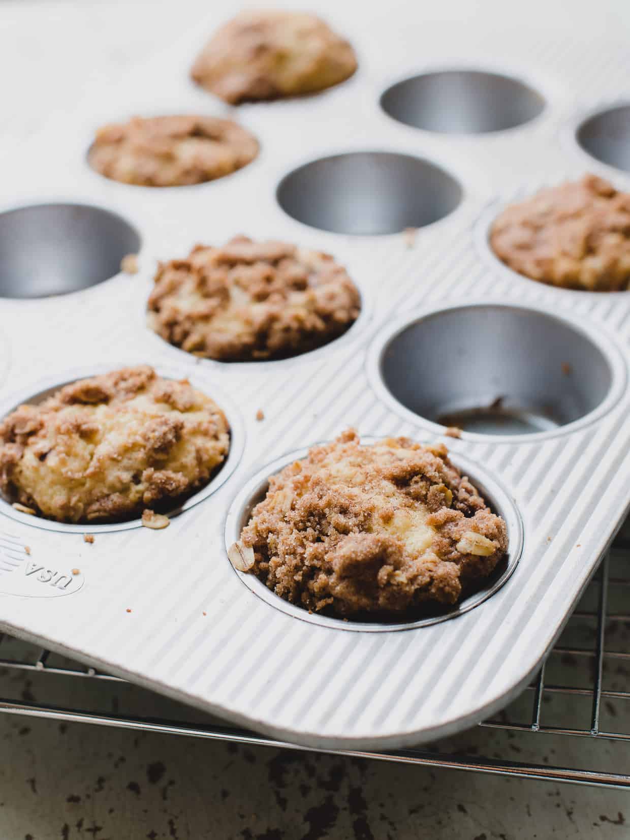 Muffin tin filled with streusel-topped Blackberry Yogurt Muffins fresh out of the oven.