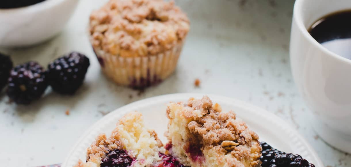 blackberry yogurt muffins cut in half on plate