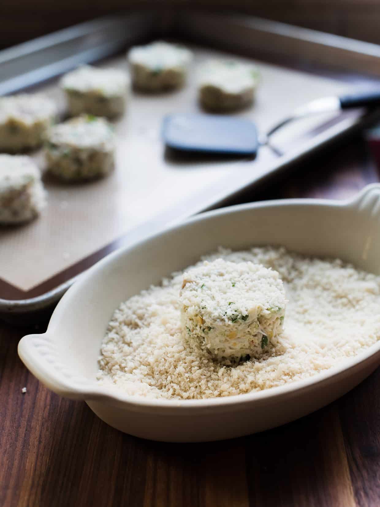 Tossing Chickpea Crab Cakes in Panko Breadcrumbs.