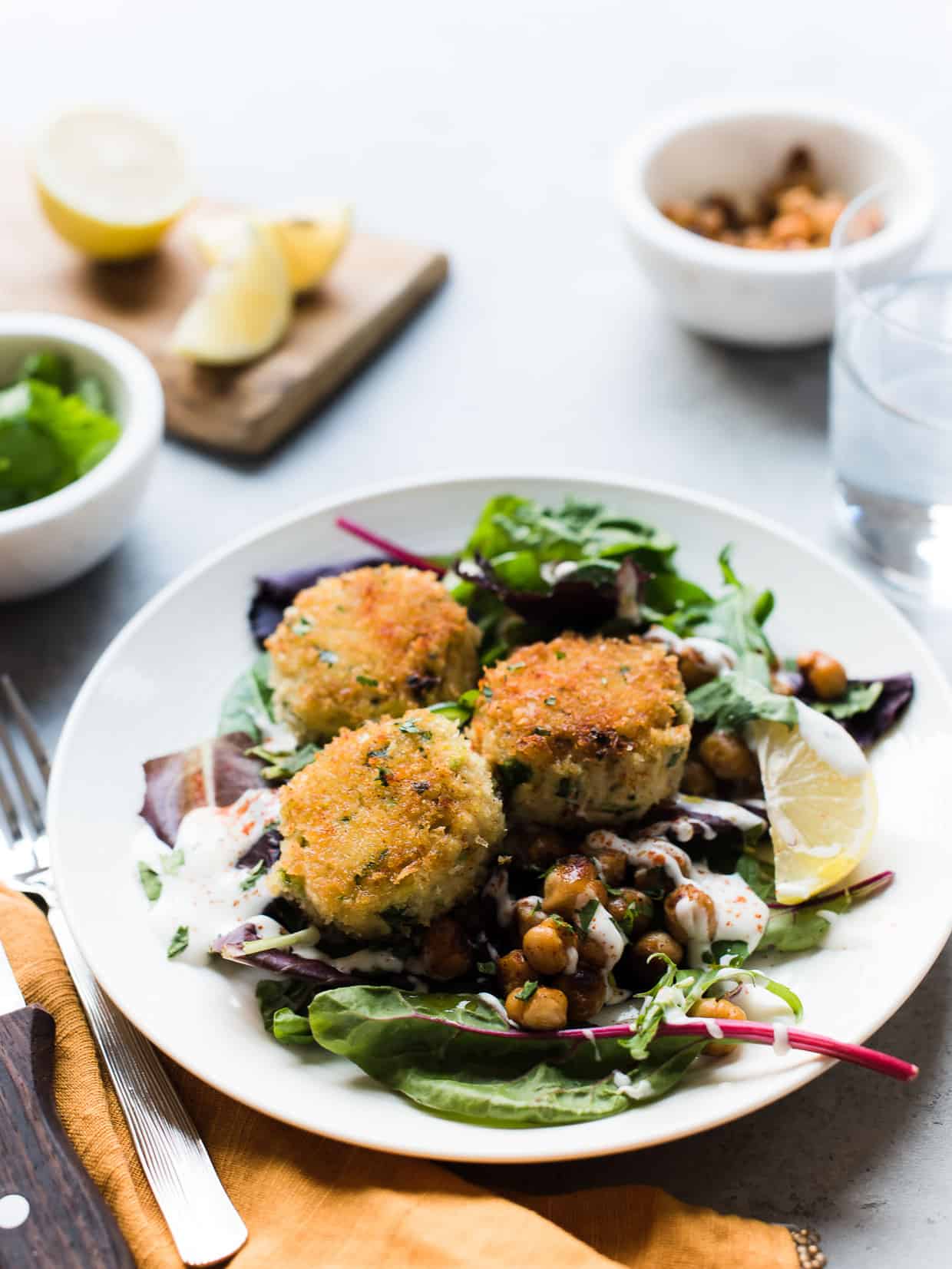 Chickpea Crab Cakes served on top of a fresh green salad.