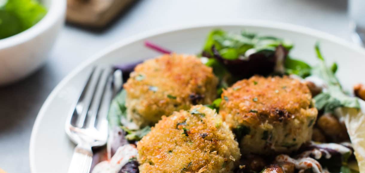 Chickpea crab cakes served on a salad with toasted chickpeas.