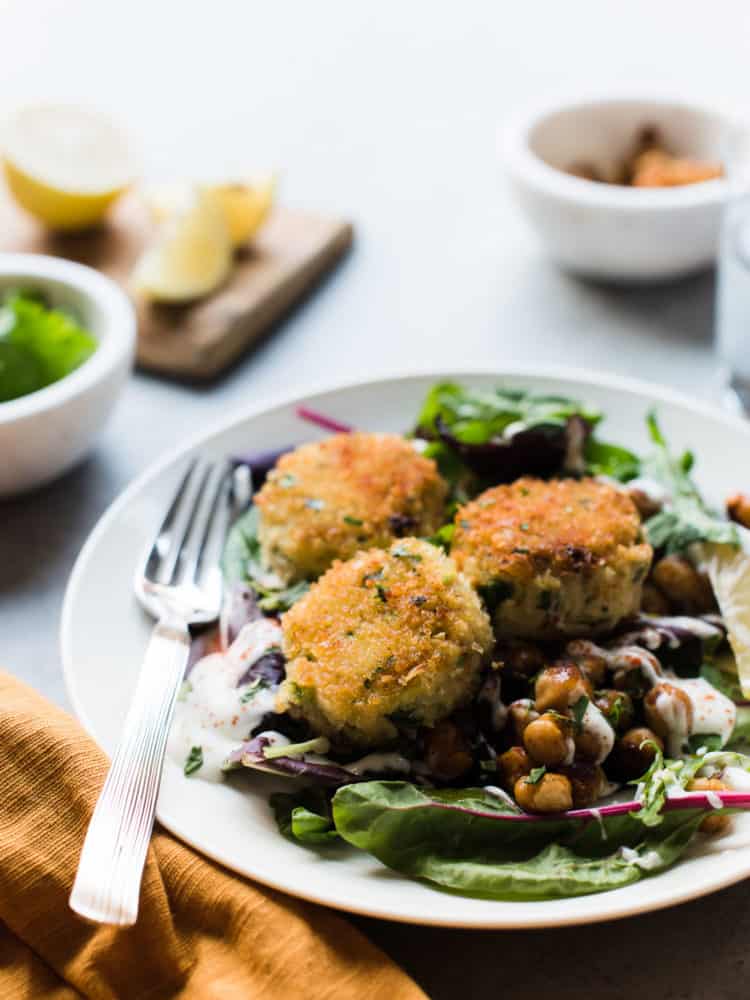 Chickpea crab cakes served on a salad with toasted chickpeas.