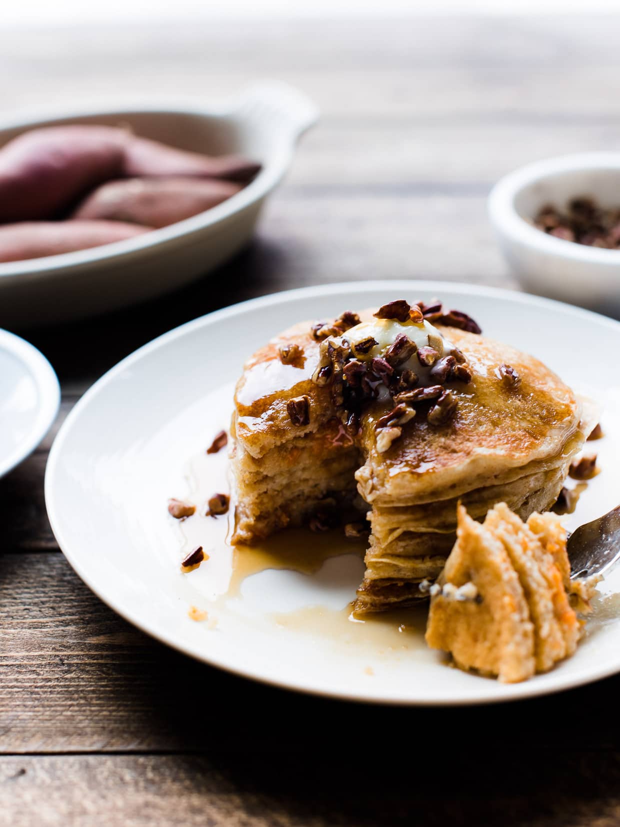 Side view of a stack of Sweet Potato Pancakes cut into with a fork and ready to eat.