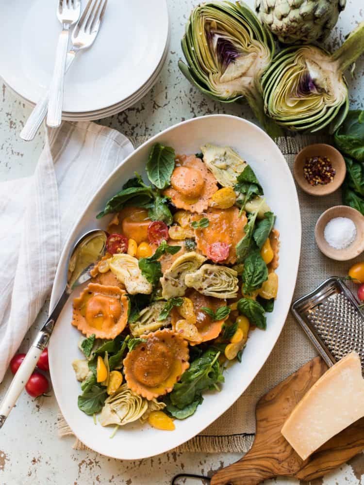 Platter of Tomato and Mozzarella Ravioli with fresh tomatoes, baby kale and artichokes.