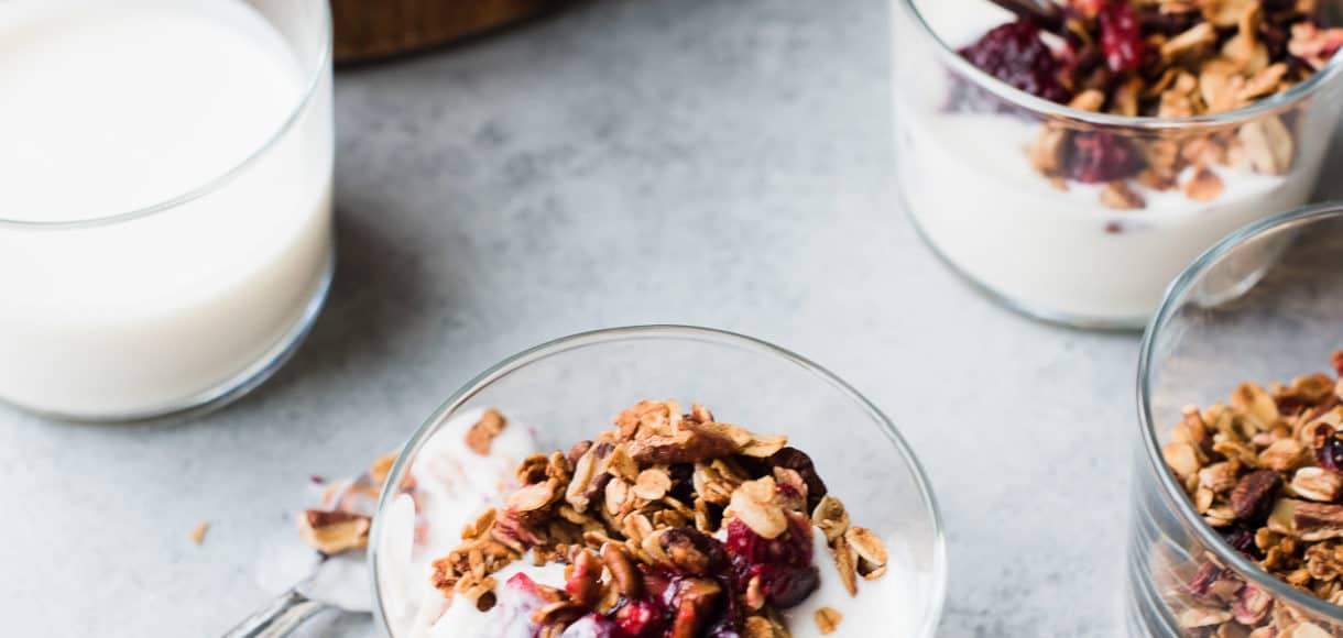 Leftover cranberry sauce granola served with yogurt in a glass.