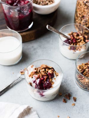Leftover cranberry sauce granola served with yogurt in a glass.