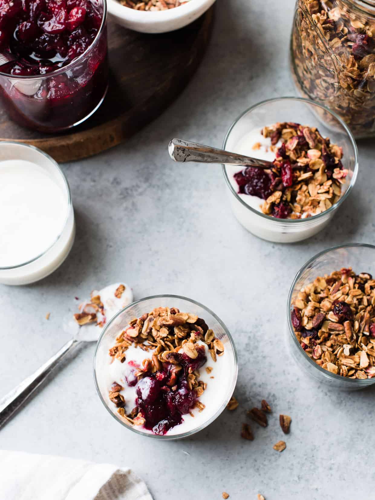 Glasses of yogurt covered with Cranberry Sauce Granola made from leftover cranberry sauce.