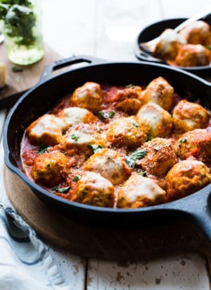 Chicken Parmesan Meatballs with melted cheese in a cast iron skillet