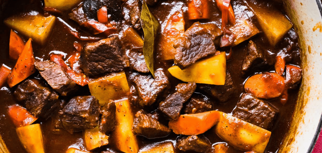 An overhead shot of beef stew in a Le Creuset dutch oven.